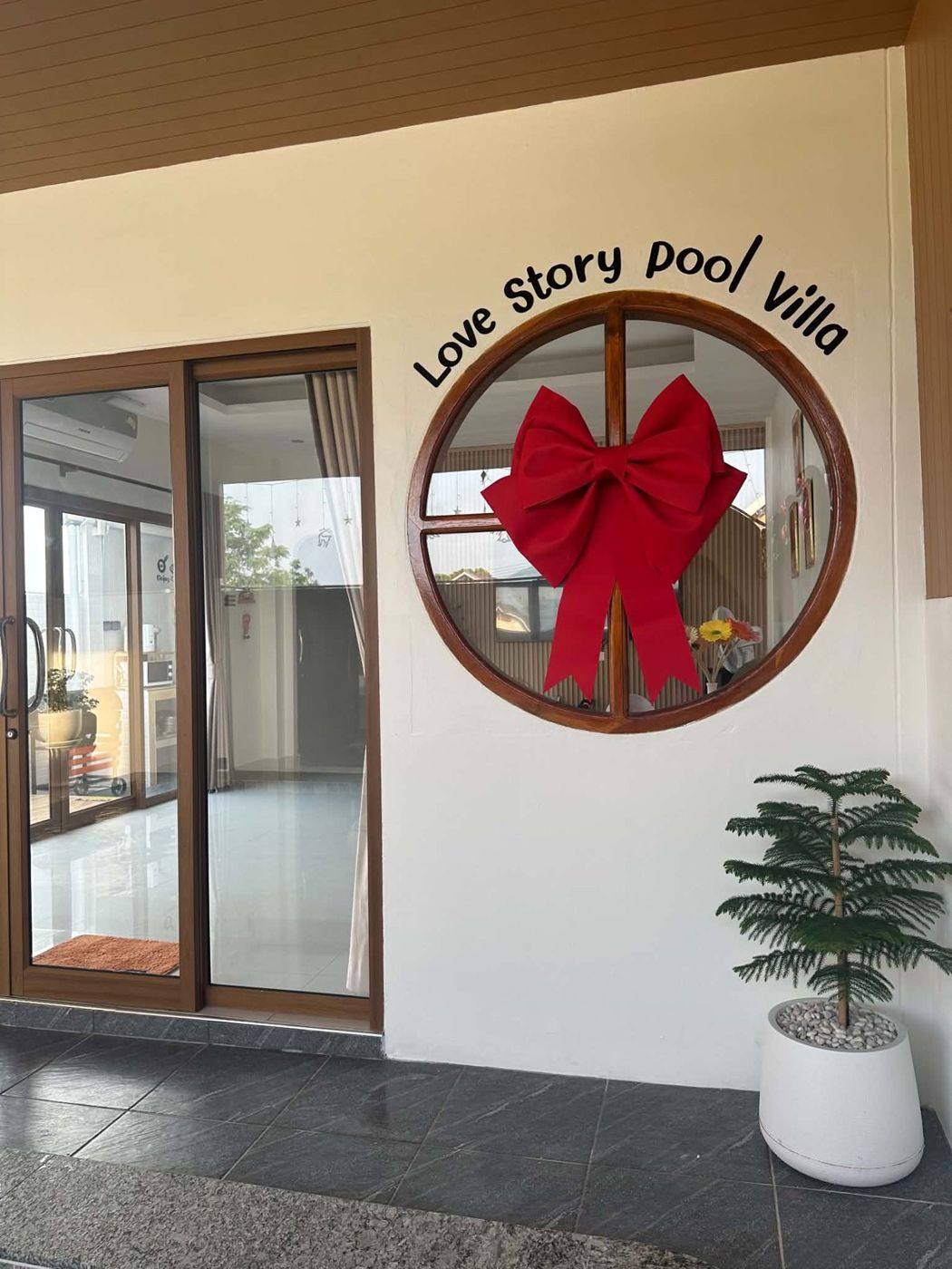 หน้าต่างวงกลมประดับโบว์แดง ใต้ป้าย Love Story pool villa